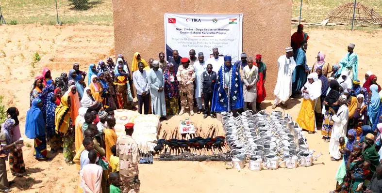 TIKA with the residents of the village gathered around 